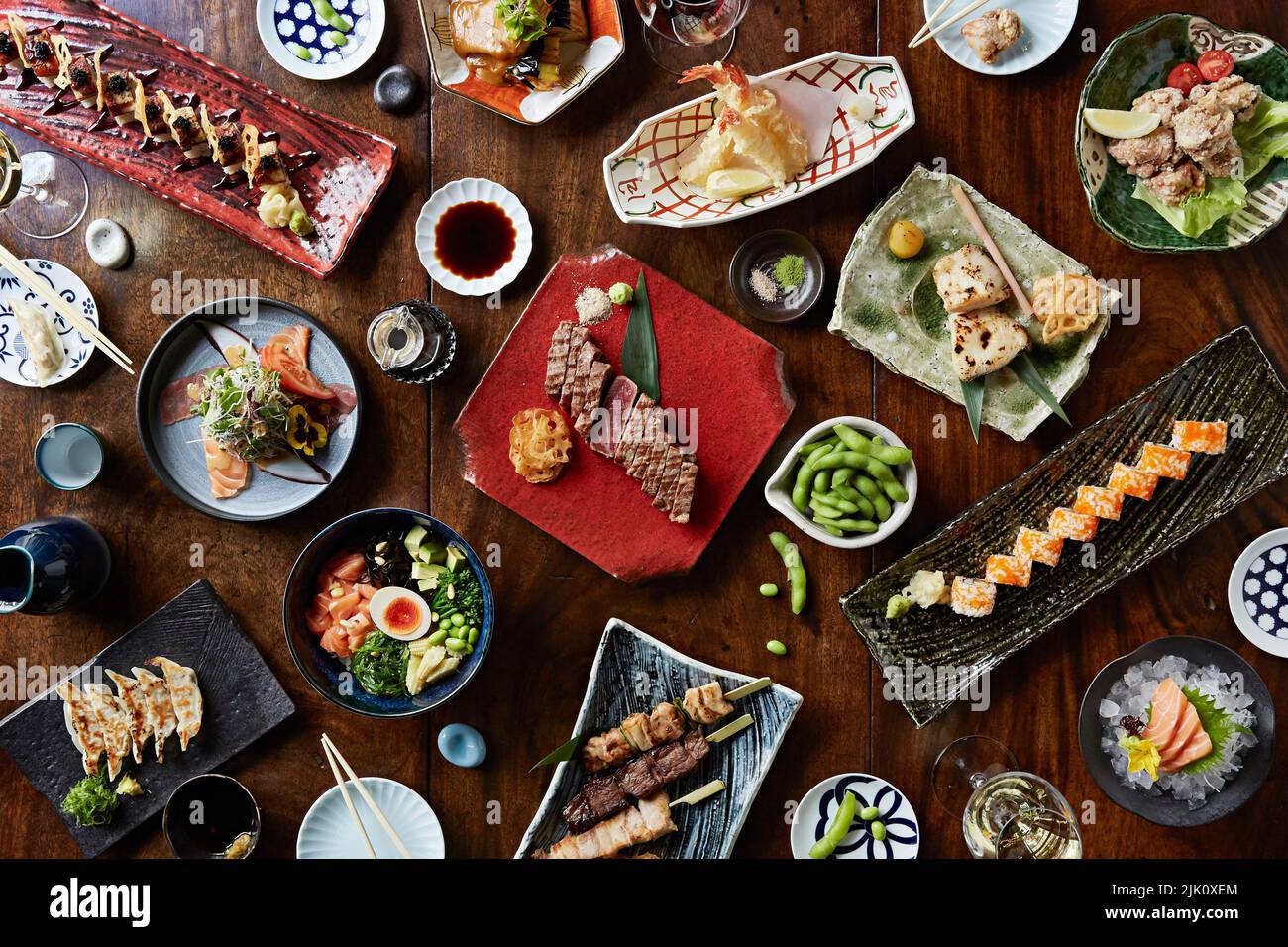 Una selección de platos japoneses, como sushi, brochetas de terayki y gyoza Foto de stock