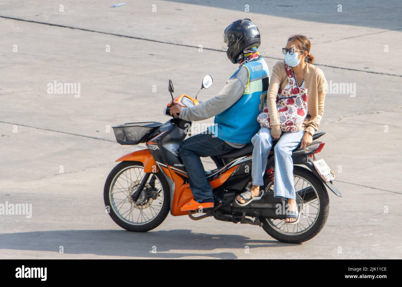 SAMUT PRAKAN, TAILANDIA, 15 2022 APR, un taxista en motocicleta viaja con una mujer. Foto de stock