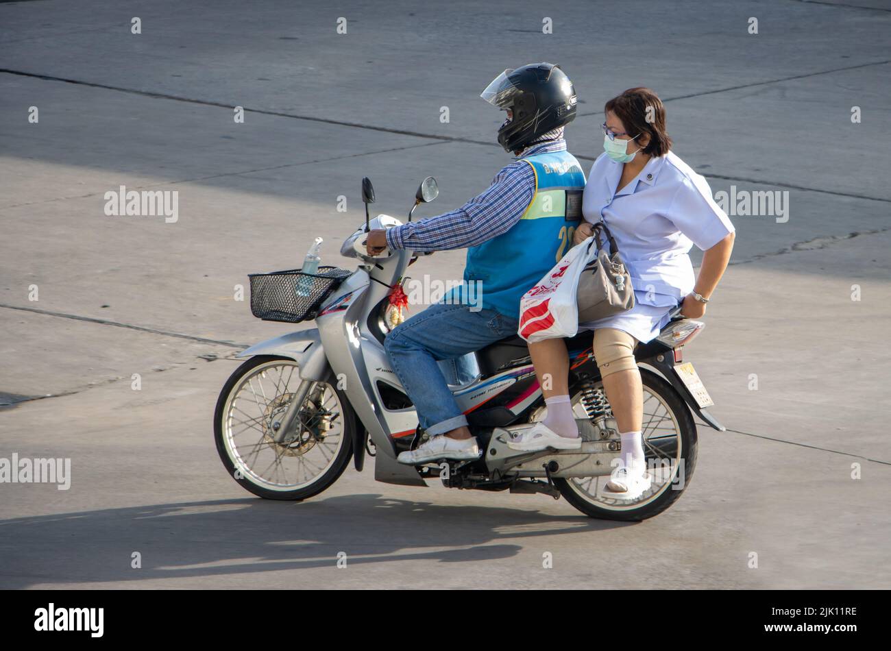 SAMUT PRAKAN, TAILANDIA, 30 2022 DE MAYO, un taxista en una motocicleta viaja con una mujer. Foto de stock