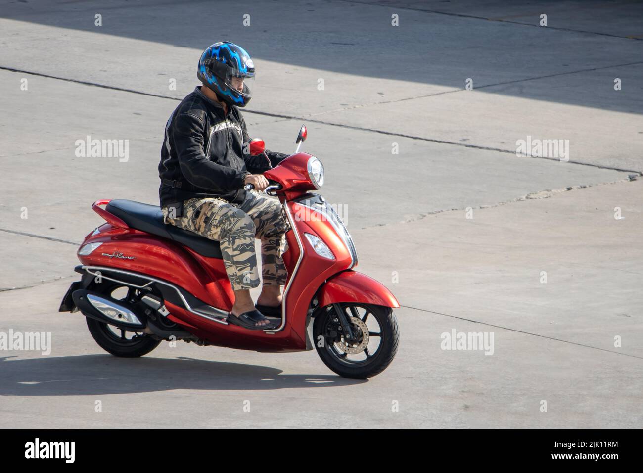 SAMUT PRAKAN, TAILANDIA, 30 2022 DE MAYO, Un hombre con casco monta una motocicleta en el camino soleado Foto de stock