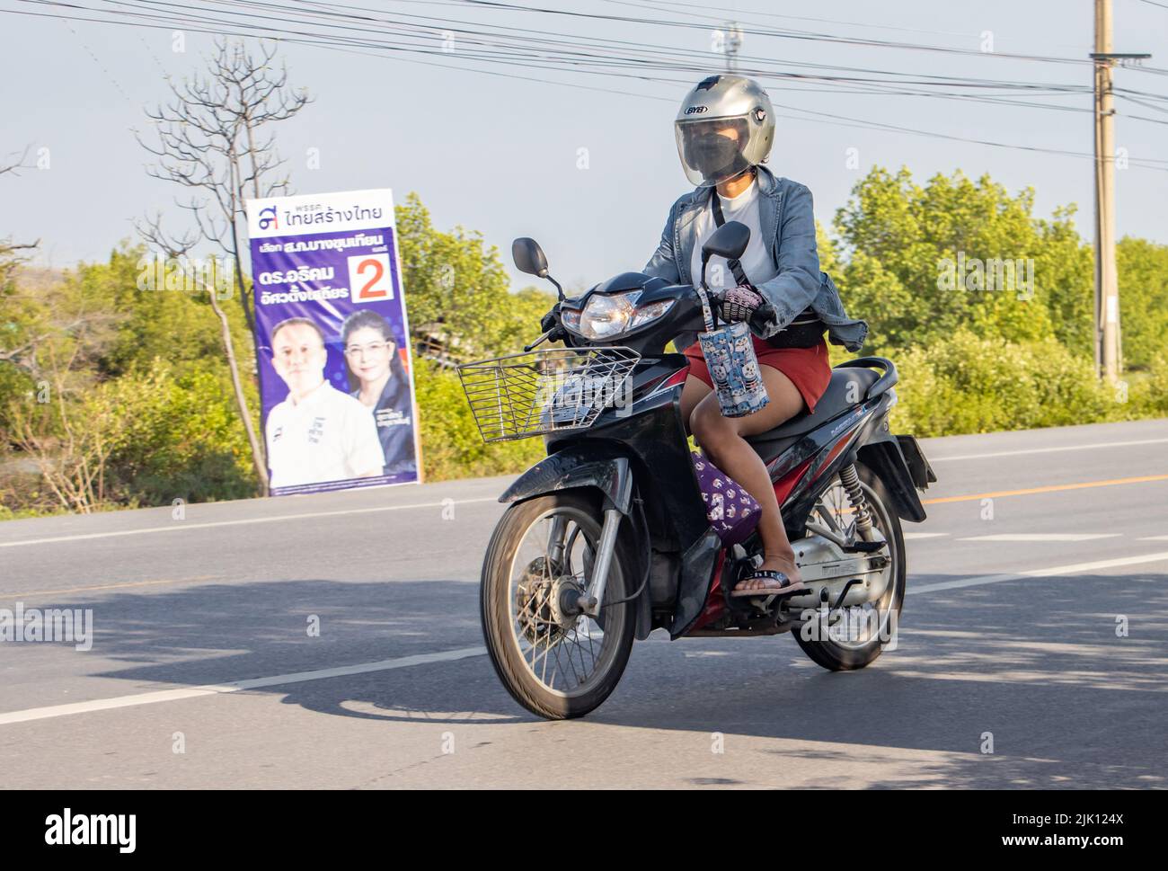 BANGKOK, TAILANDIA, ABR 29 2022, una mujer con casco y máscara monta una motocicleta Foto de stock