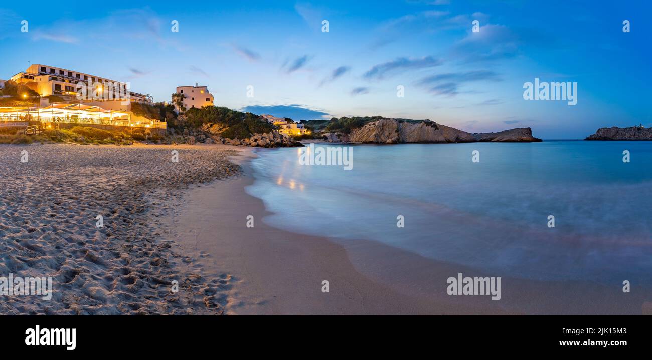 Hoteles y edificios encalados con vistas a la playa al atardecer en Arenal d'en Castell, Es Mercadal, Menorca, Islas Baleares, España Foto de stock