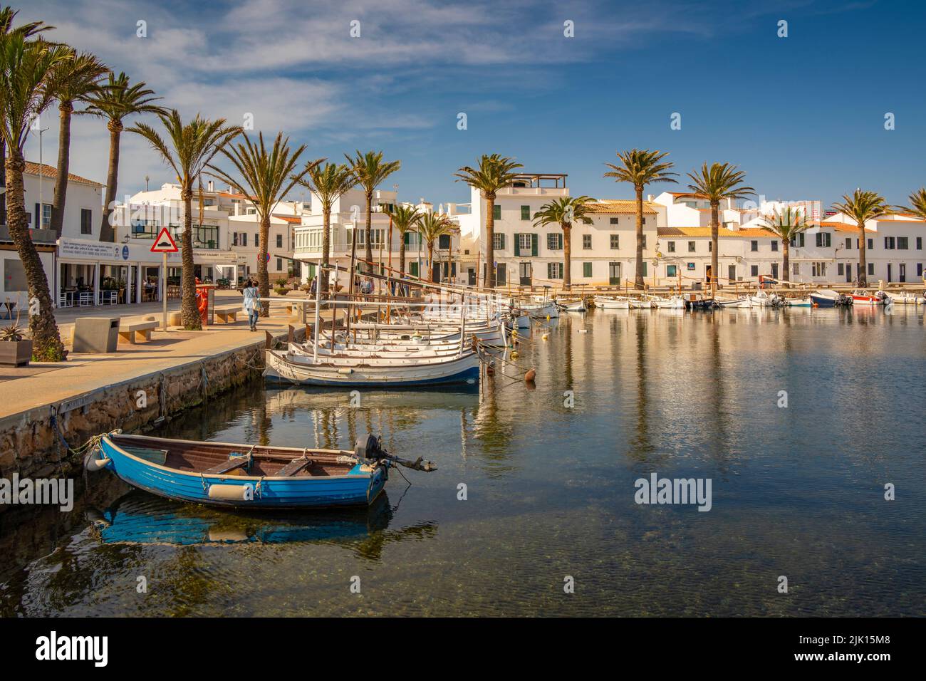 Vista de barcos y palmeras en el puerto deportivo y casas en Fornelles, Fornelles, Menorca, Islas Baleares, España, Mediterráneo, Europa Foto de stock