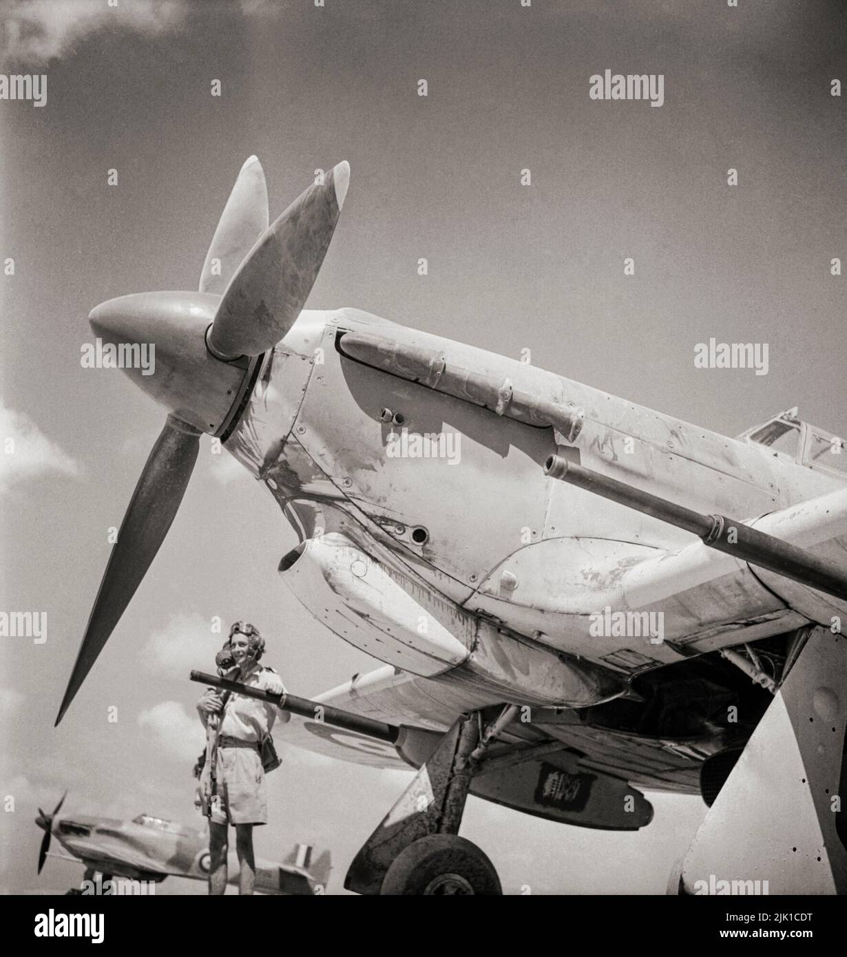 Un piloto del Escuadrón Nº 6 de la RAF en Egipto, por su Huracán Hawker Mark IID mostrando el cañón antitanque Vickers 40mm utilizado a buen efecto en los combates en el norte de África. El Hurricane, un avión de combate británico de un solo asiento de los años 1930s–40s, fue eclipsado en la conciencia pública por el Supermarine Spitfire durante la Batalla de Gran Bretaña en 1940, pero el Huracán infligió el 60 por ciento de las pérdidas sufridas por la Luftwaffe en el combate, Y luchó en todos los grandes teatros de la Segunda Guerra Mundial. Foto de stock