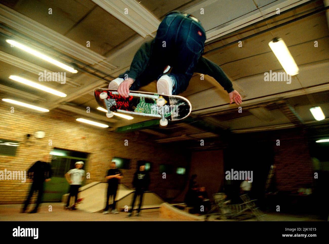 Un skateboarder en una sala de skate. Foto de stock
