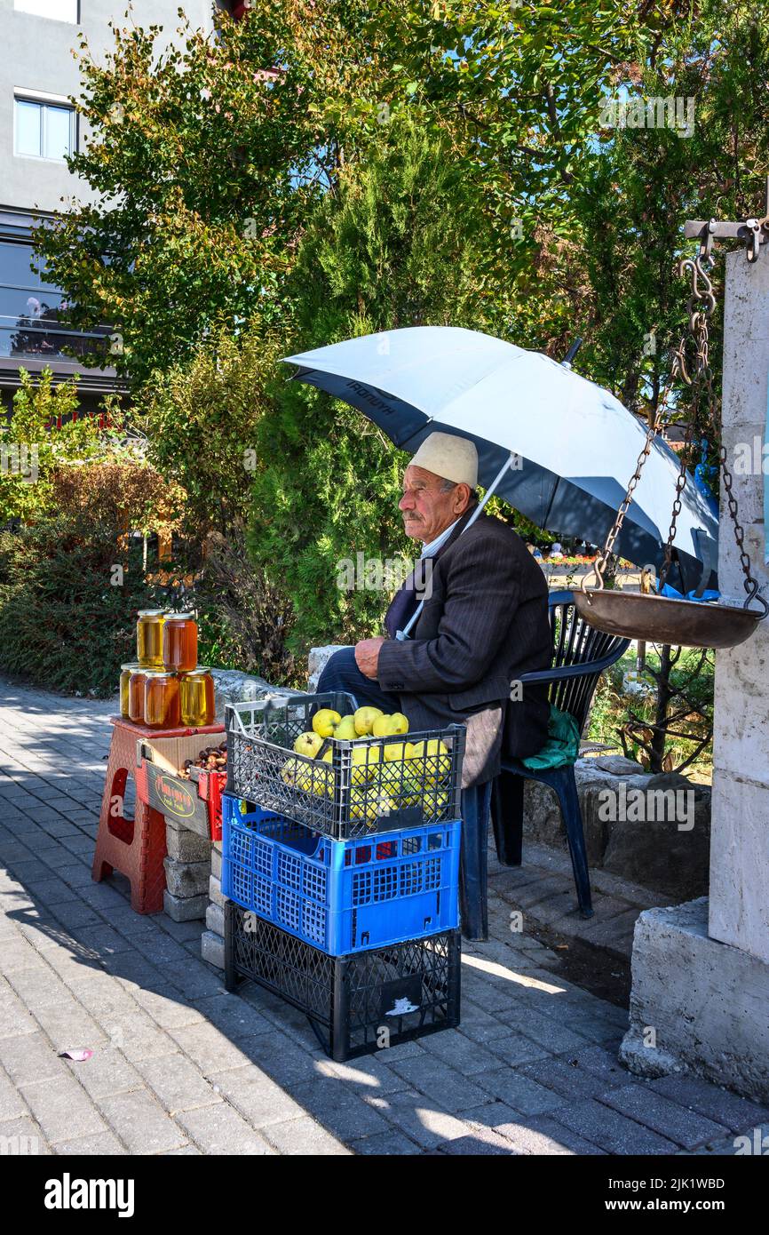Un vendedor callejero que vende fruta y miel en la ciudad de Tetovo, en el norte de Macedonia. Foto de stock