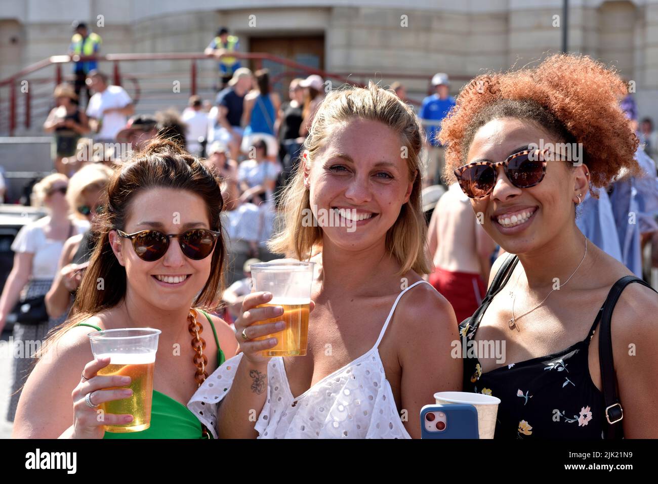 Tres mujeres felices en una multitud en el festival del puerto de Bristol, Reino Unido Foto de stock
