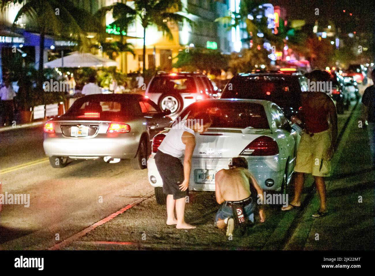 Miami Beach Florida, South Beach Ocean Drive noche vida nocturna vehículos de tráfico, lugares de interés de los visitantes, grupo de personas escena persona Foto de stock