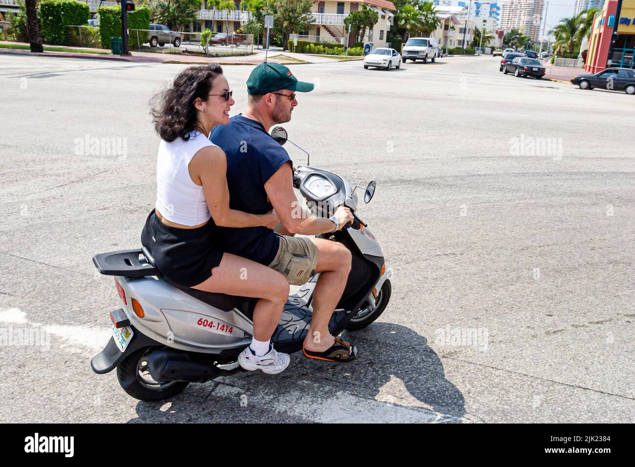 Miami Beach Florida,South Beach Ocean Drive pareja adultos hombre hombres hombres mujer mujer mujer mujer mujer mujer, sin cascos scooter Foto de stock
