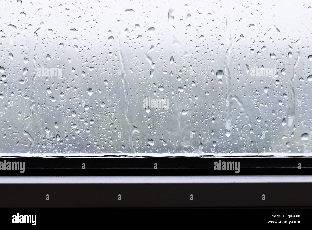 gotas de lluvia y gotas de lluvia primer plano en la ventana con lluvia fuerte Foto de stock