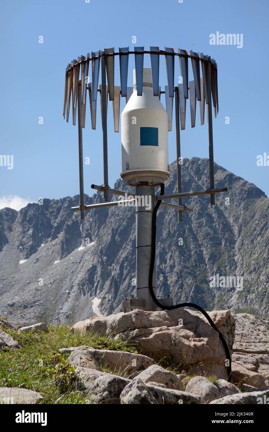 Equipo de pluviómetro blindado, instrumentación meteorológica, en las montañas Foto de stock