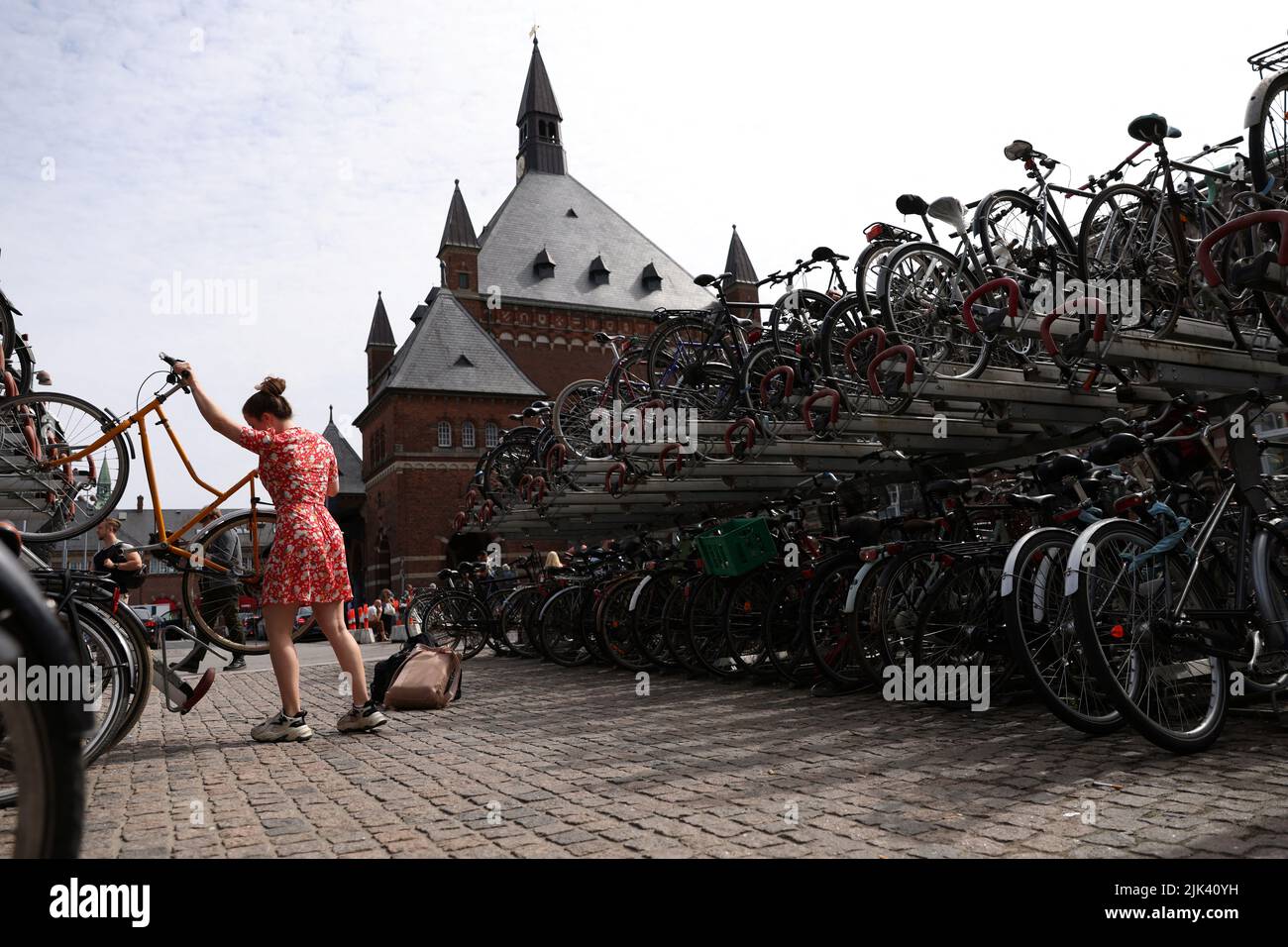 Una persona coloca una bicicleta en un estante fuera de la Estación Central de Copenhague en Copenhague, Dinamarca, 30 de julio de 2022. REUTERS/Andrew Kelly Foto de stock