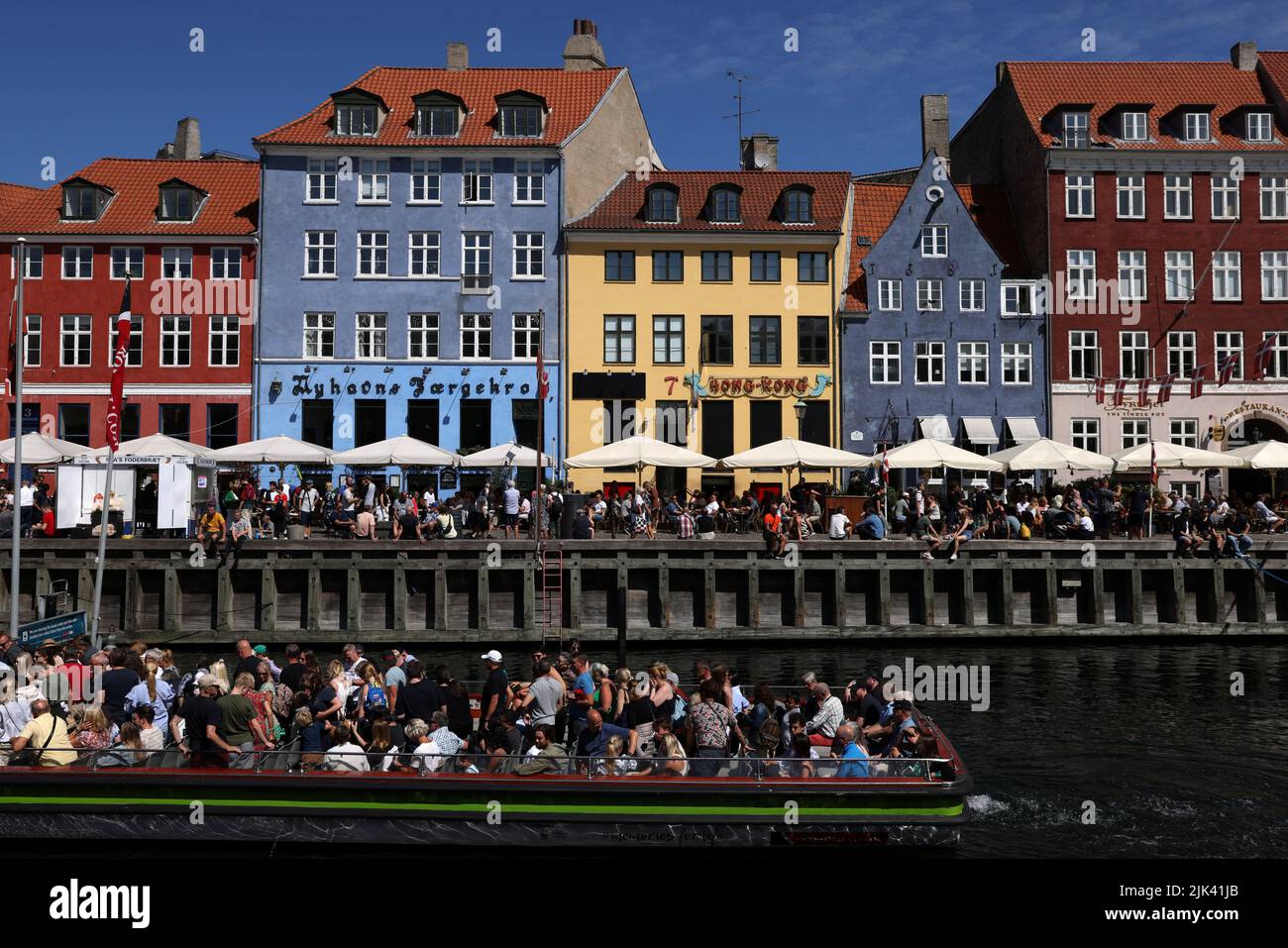 La gente viaja en un barco por los canales en Nyhavn, Copenhague, Dinamarca, 30 de julio de 2022. REUTERS/Andrew Kelly Foto de stock