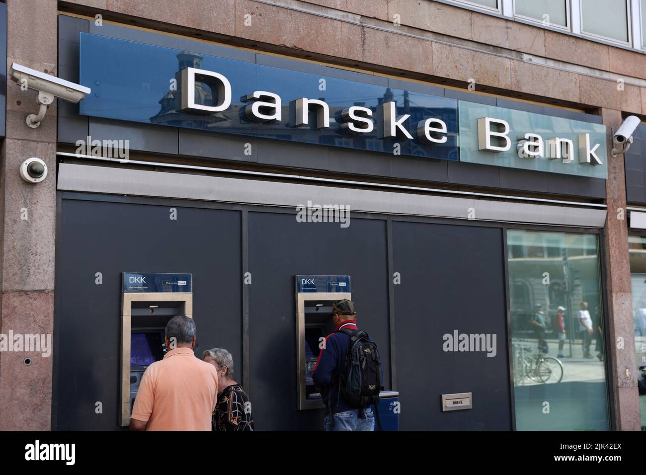 La gente usa cajeros automáticos en una sucursal de Danske Bank en Copenhague, Dinamarca, 29 de julio de 2022. REUTERS/Andrew Kelly Foto de stock