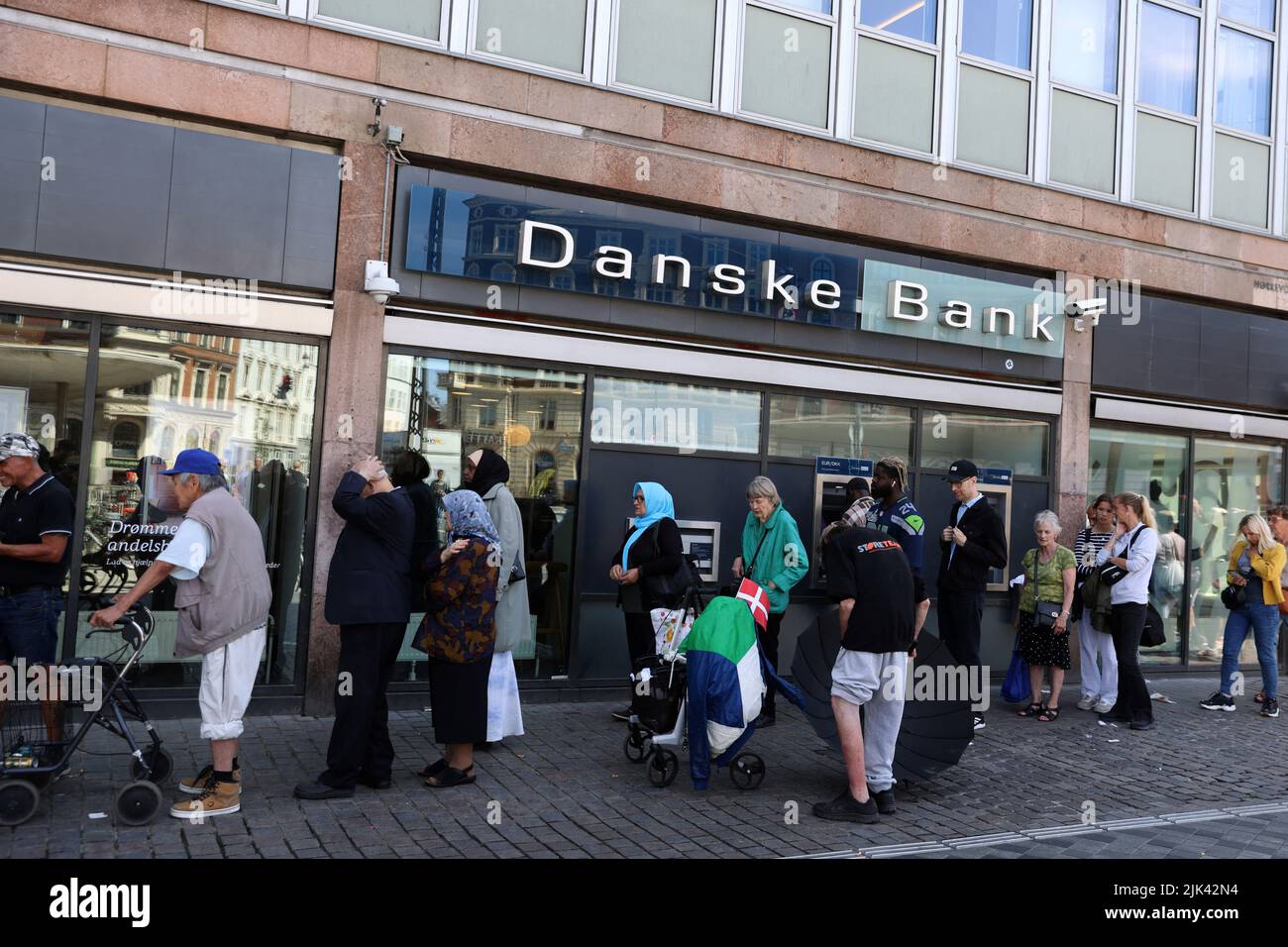 La gente hace cola en una sucursal de Danske Bank en Copenhague, Dinamarca, 29 de julio de 2022. REUTERS/Andrew Kelly Foto de stock