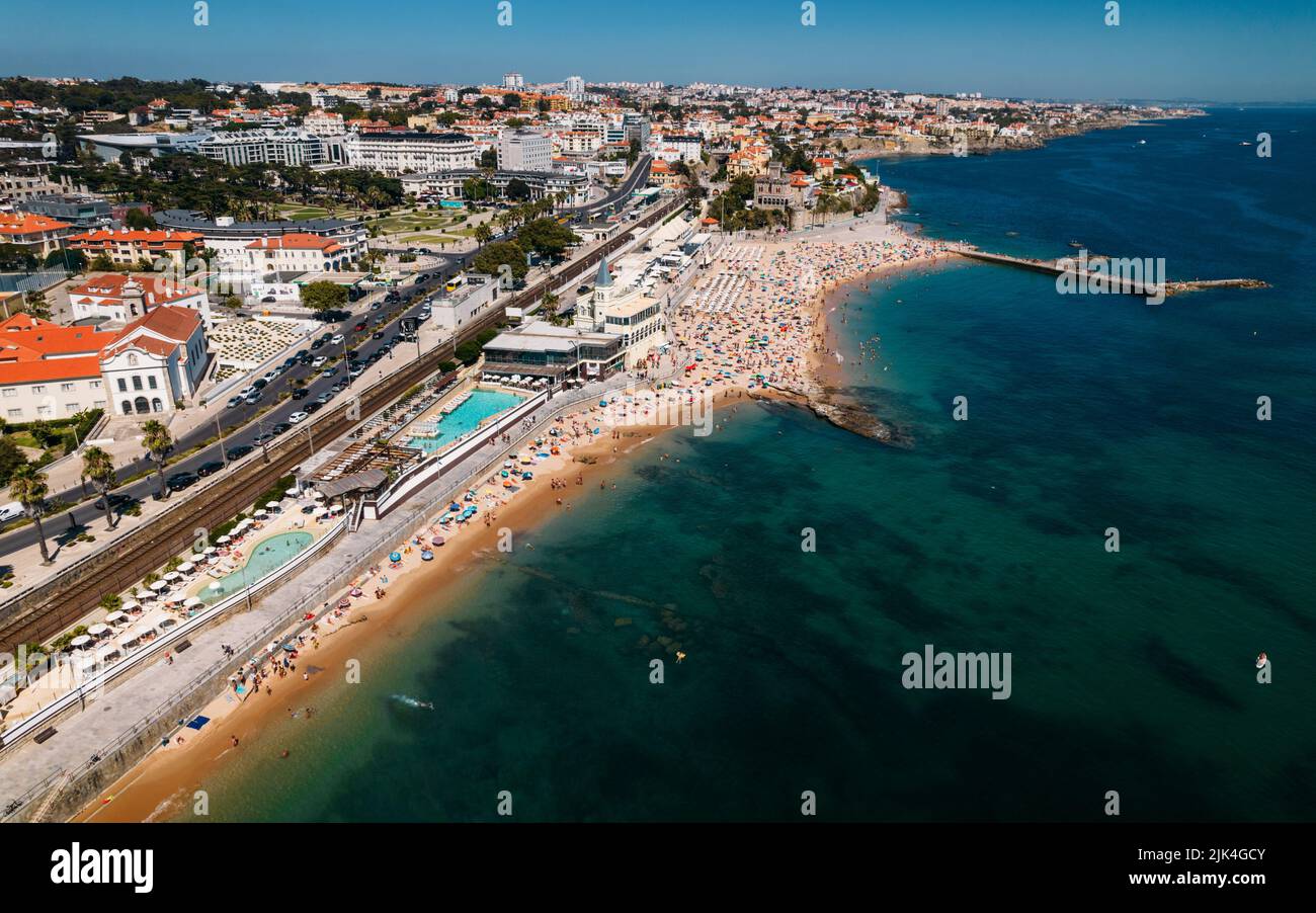 Vista aérea en avión de la concurrida playa de Tamariz en Estoril, Portugal durante el verano Foto de stock