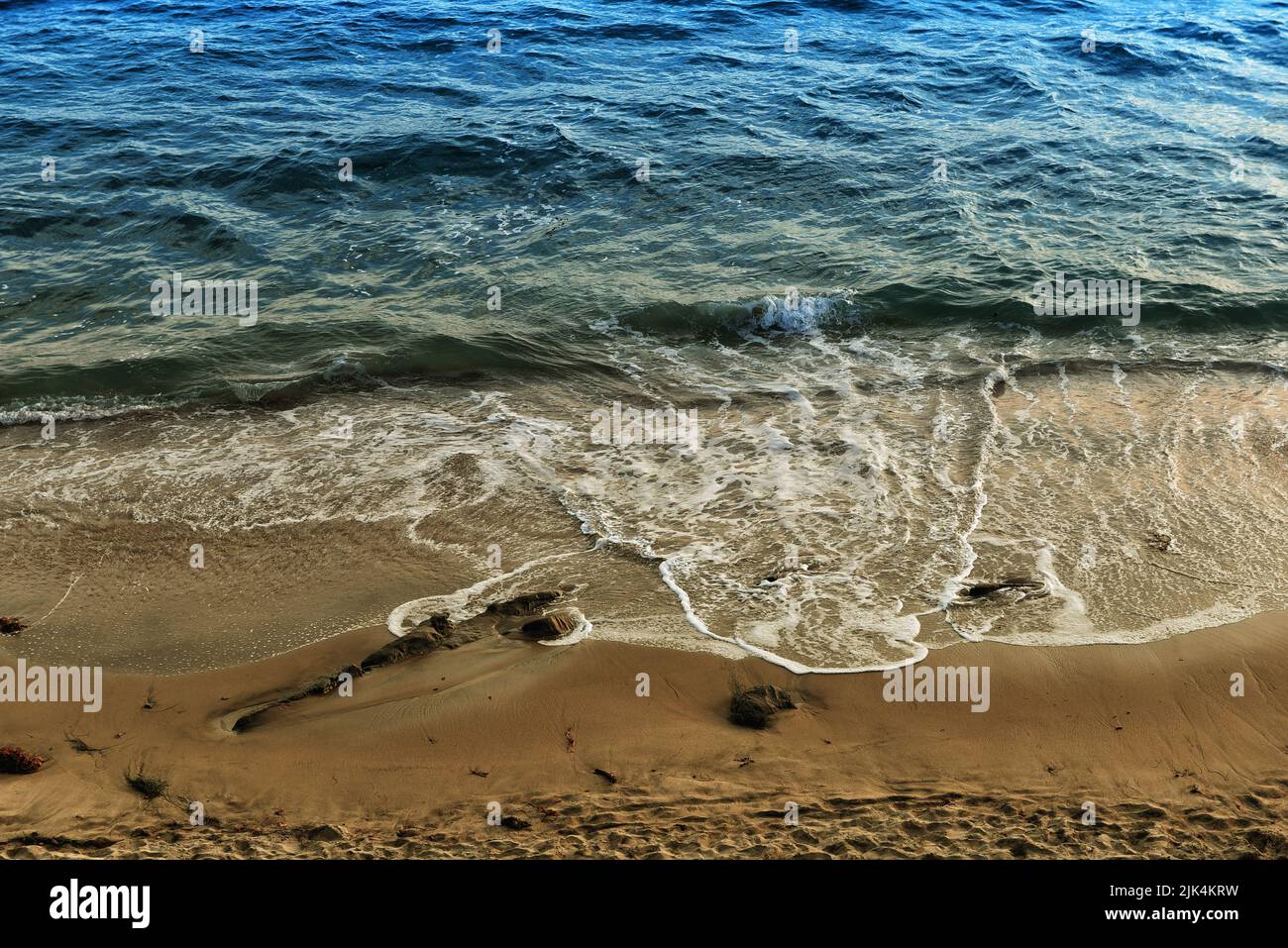 Suaves olas y espuma marina en la costa sur de California, desde los acantilados de Laguna Beach. Foto de stock