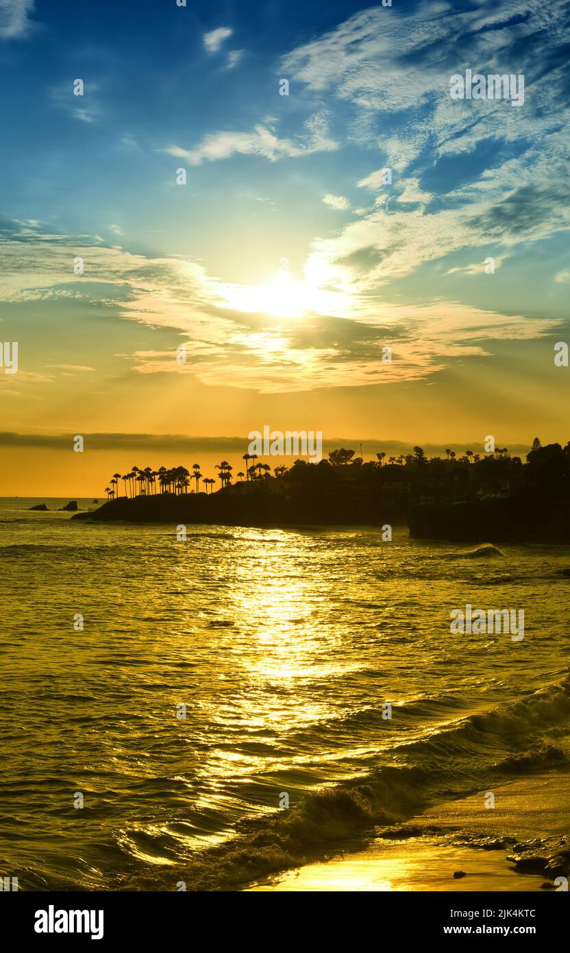 Hermoso cielo de puesta de sol sobre Laguna Beach con reflejos dorados en el agua. Foto de stock