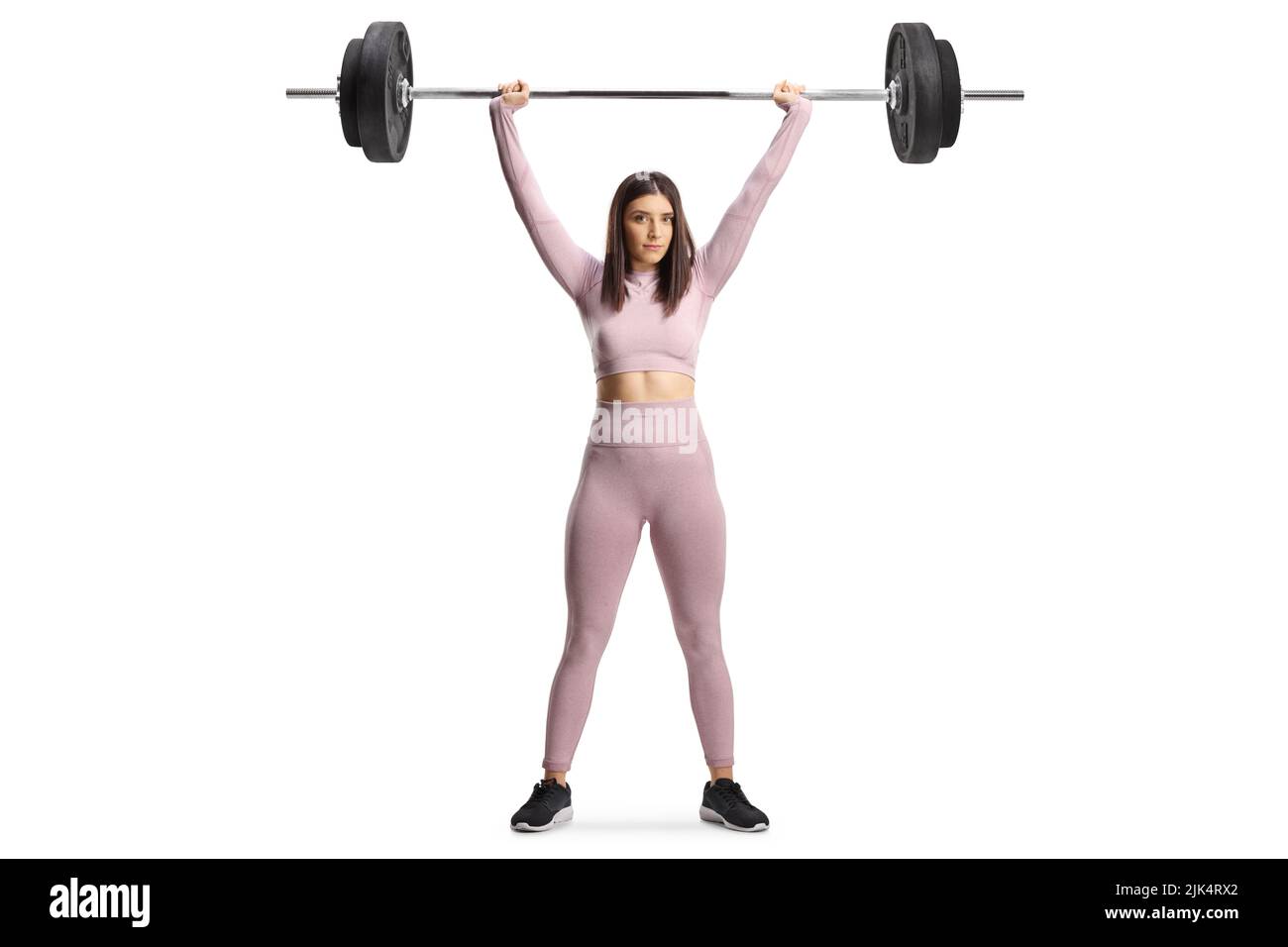 Retrato completo de una mujer joven fuerte que ejerce levantamiento de pesas aislada sobre fondo blanco Foto de stock