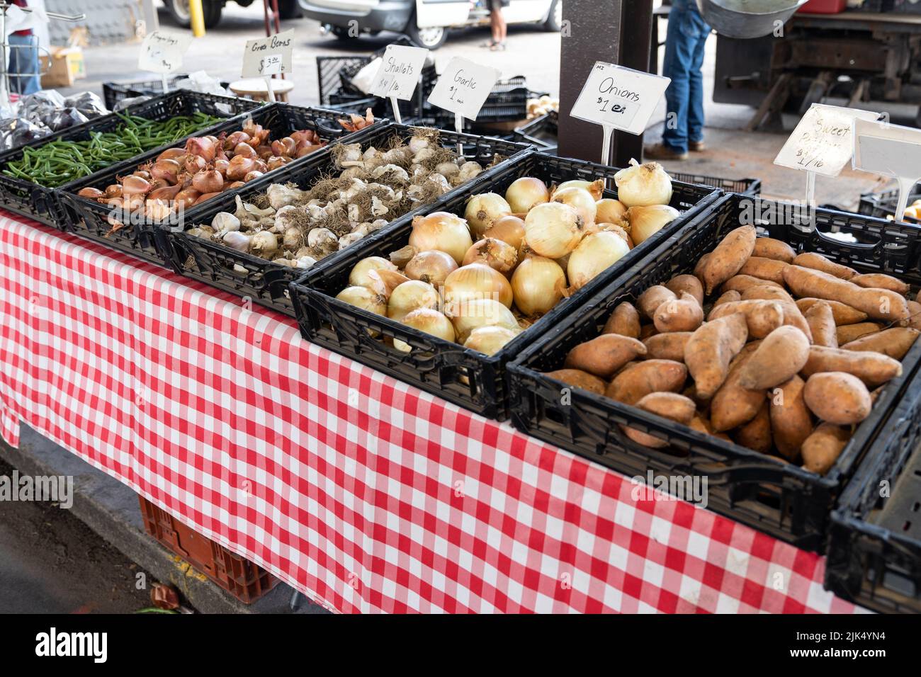 Cebollas, ajos, chalotas, batata y judías verdes en el mercado de un agricultor Foto de stock