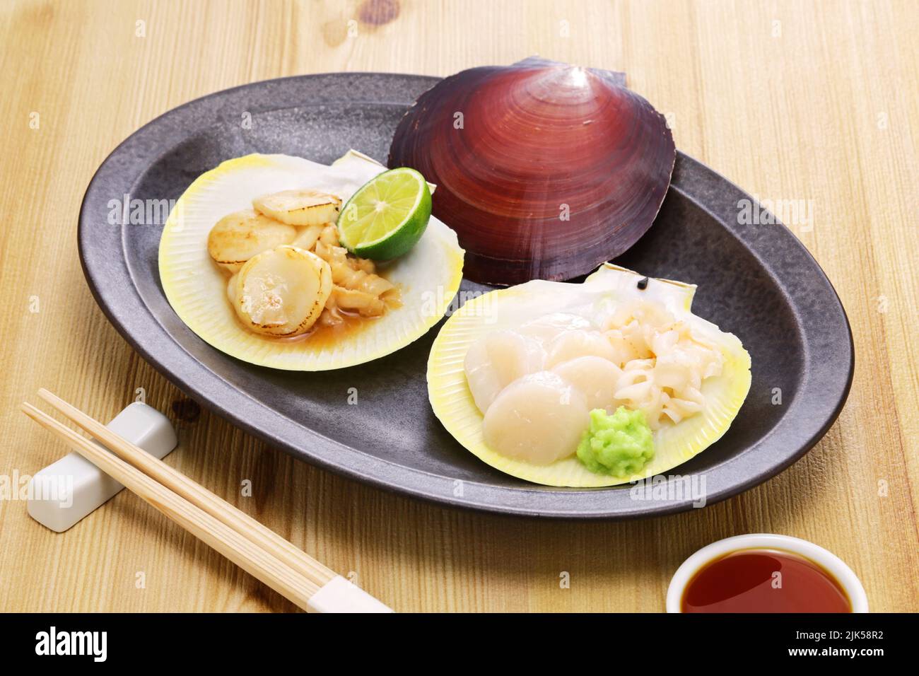 Plato de vieiras japonesas, sashimi y salteado con mantequilla y salsa de soja Foto de stock