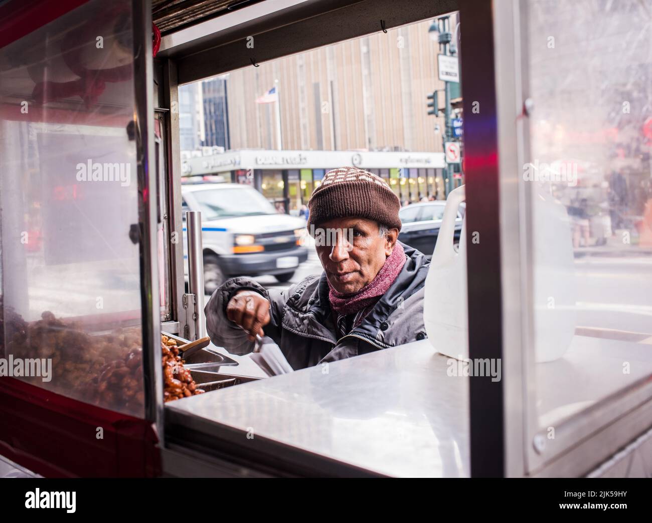 Nueva York, NY/USA - 05-07-2016: Camión de comida con vendedor ambulante sirviendo nueces. Foto de stock