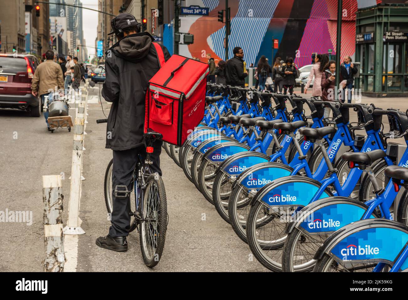 Nueva York, NY/USA - 05-07-2016: Mensajero de la bicicleta que lleva refrigerador rojo de la entrega de la comida en Manhattan. Foto de stock