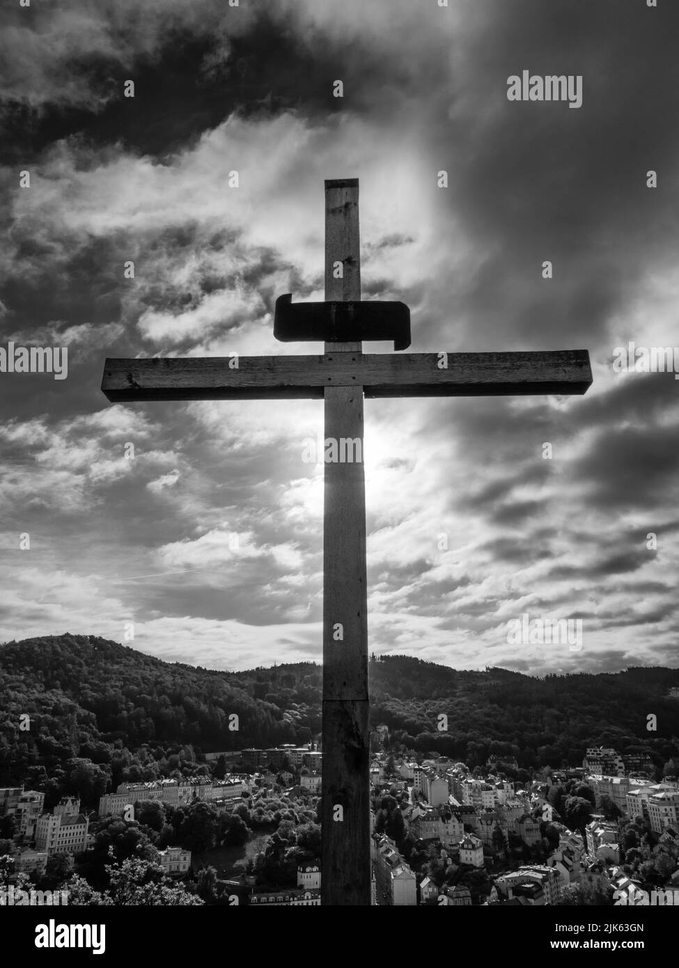 Christian Cross on Peter's Height Lookout o Petrova Vysina en Karlovy Vary, Bohemia, República Checa en un dramático blanco y negro Foto de stock