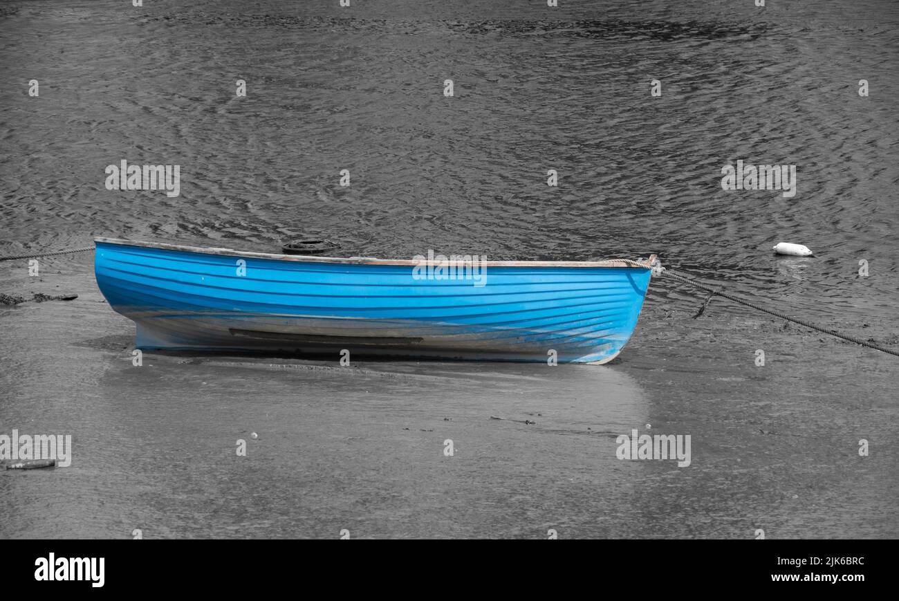 Un barco de remo azul se cogió contra una imagen en blanco y negro del río Camel en Wadebridge Foto de stock