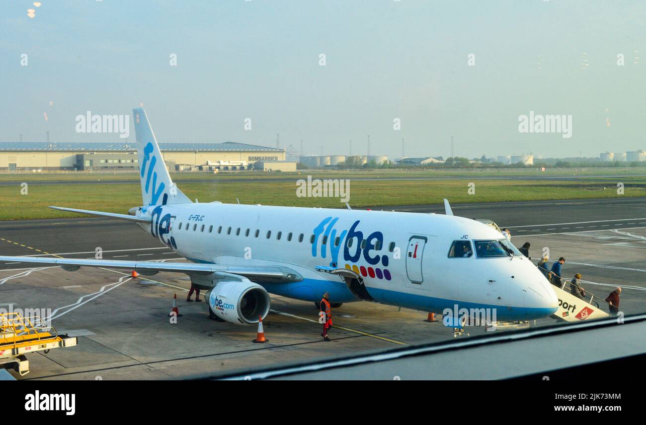 Belfast, Reino Unido, abril de 2019. Los pasajeros salen del avión Flybe en el aeropuerto de Belfast en un día soleado. Foto de stock