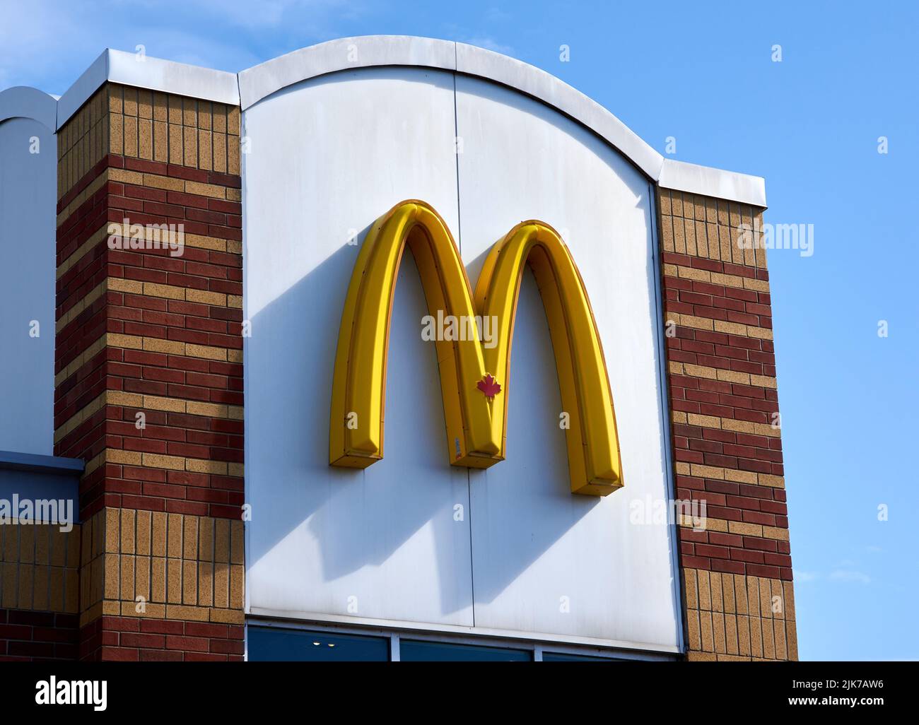 Montreal, Canadá - 4 de abril de 2022: Logotipo de McDonald en el edificio del restaurante. McDonald's es la cadena de restaurantes más grande del mundo en cuanto a ingresos, sirviendo ovas Foto de stock