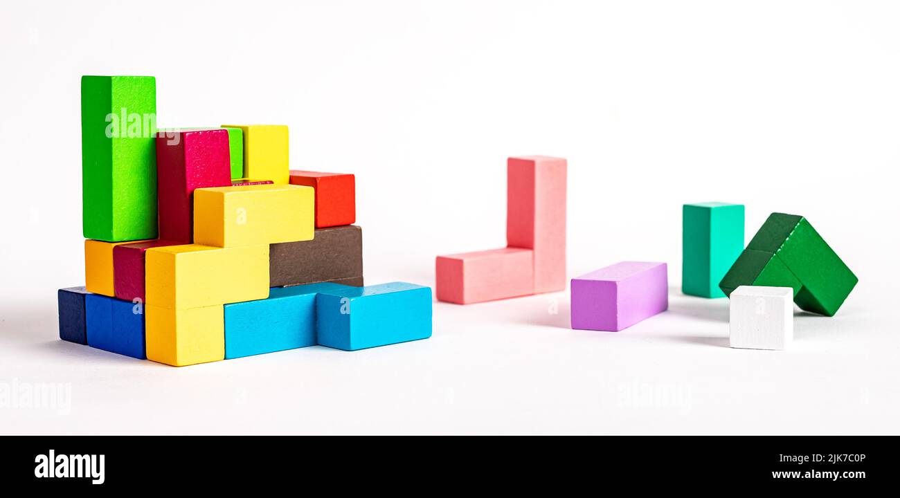 Coloridos elementos de madera del puzzle tetris. Construcción, concepto de formación. Juego lógico de niños para el desarrollo de habilidades de resolución de problemas. Fotografía de alta calidad Foto de stock