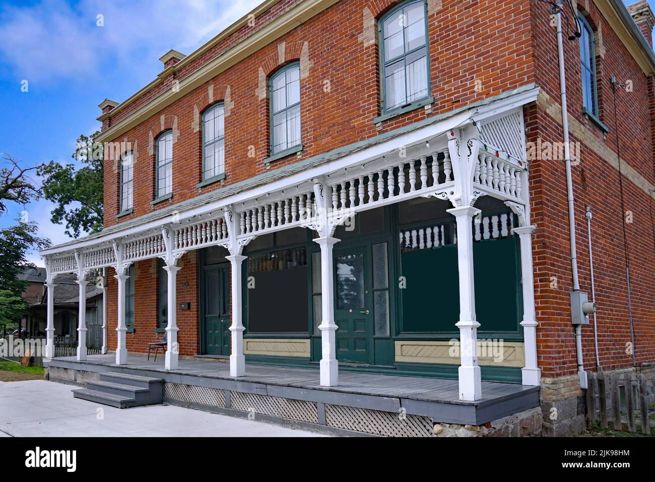 Antiguo edificio de ladrillo con porche frontal de ancho completo, originalmente una tienda rural de los años 1890s Foto de stock