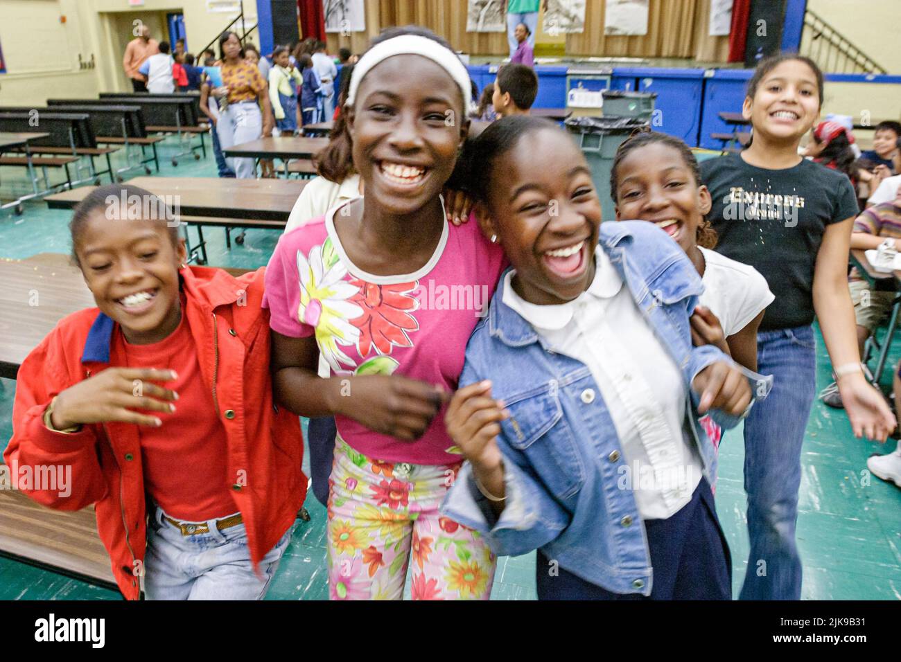 Miami Florida,Escuela Primaria Frederick Douglass,comunidad de barrio de bajos ingresos,estudiantes africanos negros niñas amigas cafetería comedor mesas Foto de stock