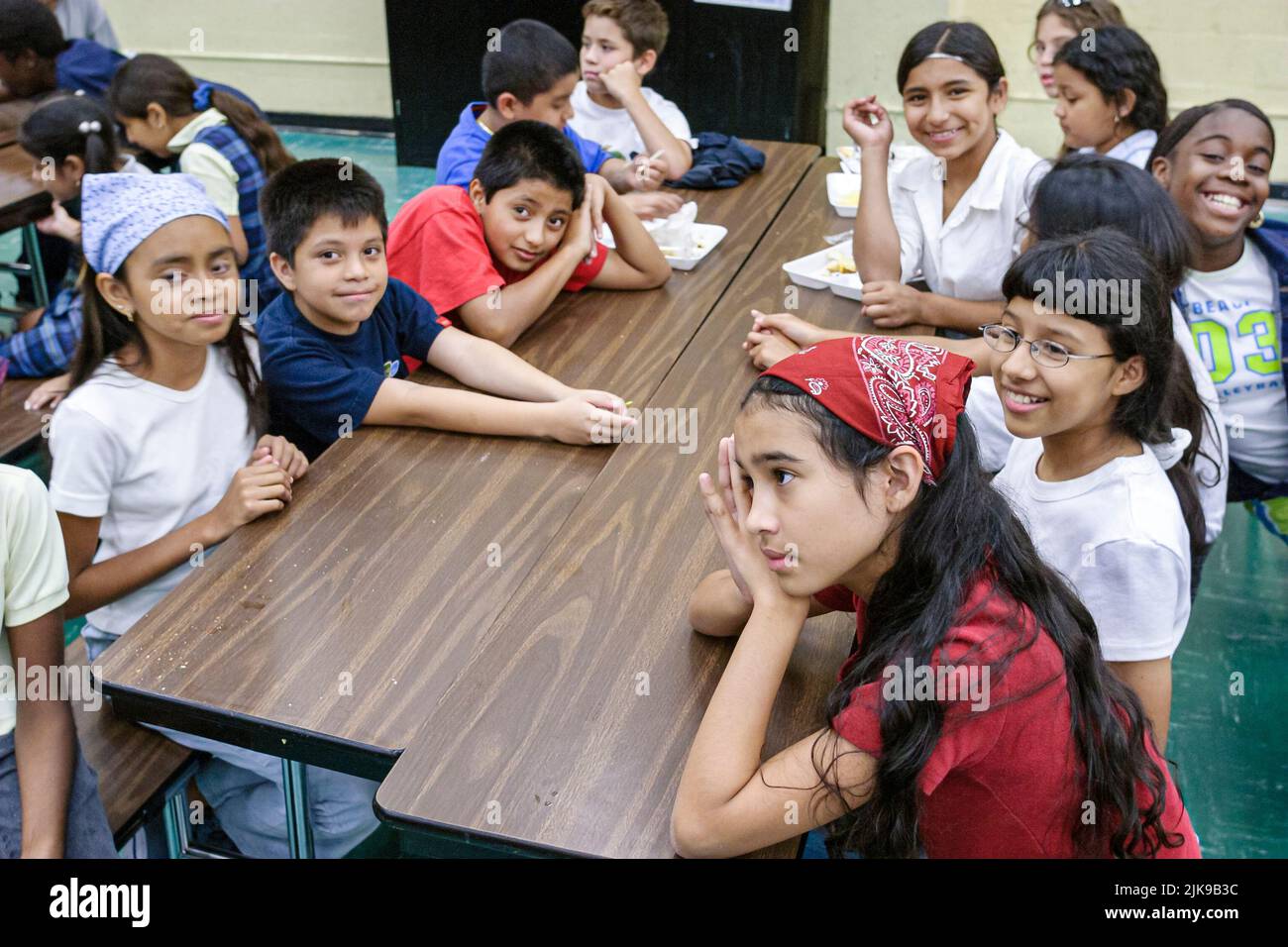 Miami Florida,Escuela Primaria Frederick Douglass,dentro,comunidad de bajos ingresos,negros estudiantes hispanos niñas niños niños salón mesa de mesa Foto de stock