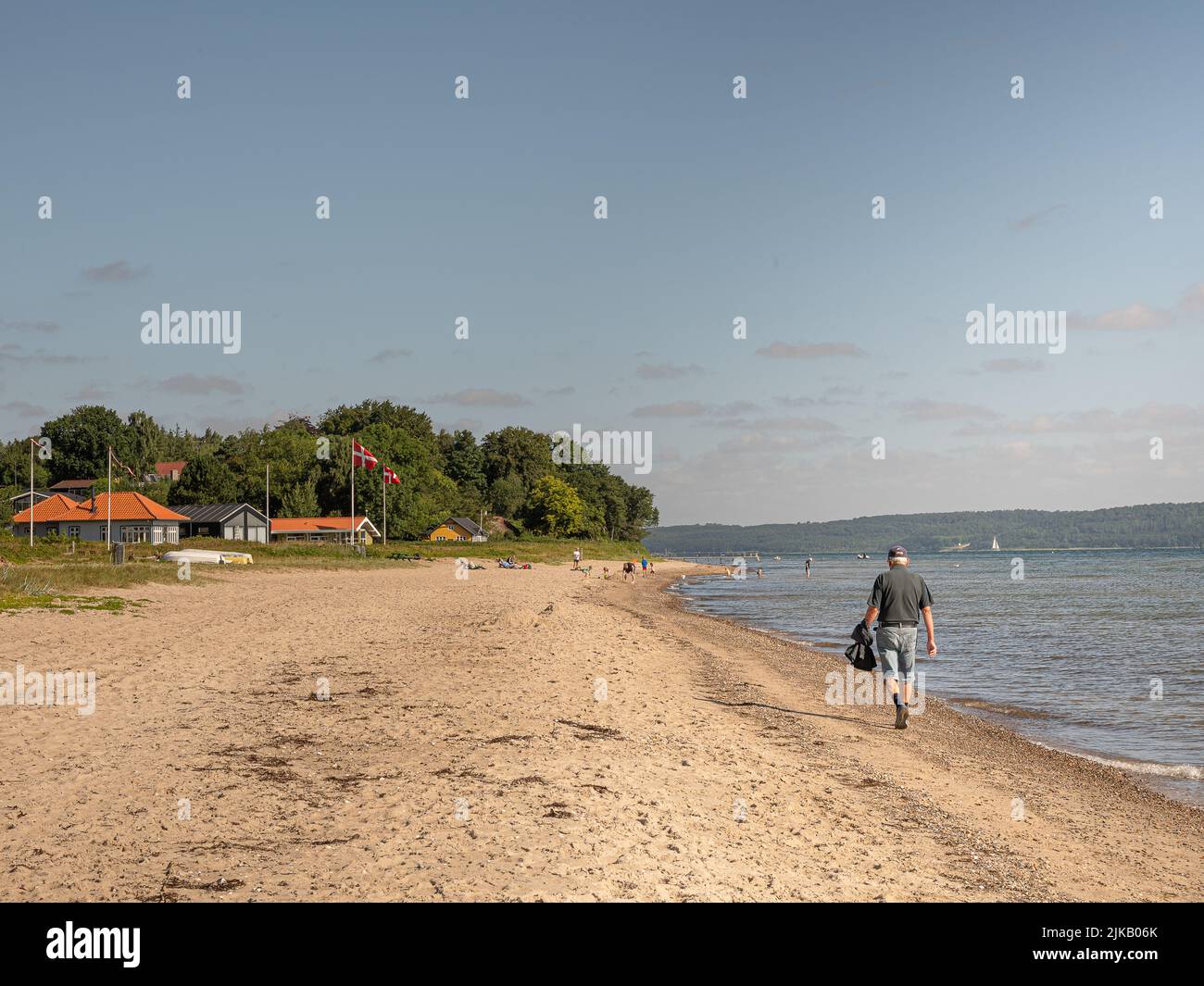 Hombre caminando por la playa en Høll, Vejle, Dinamarca, 1 de agosto de 2022 Foto de stock