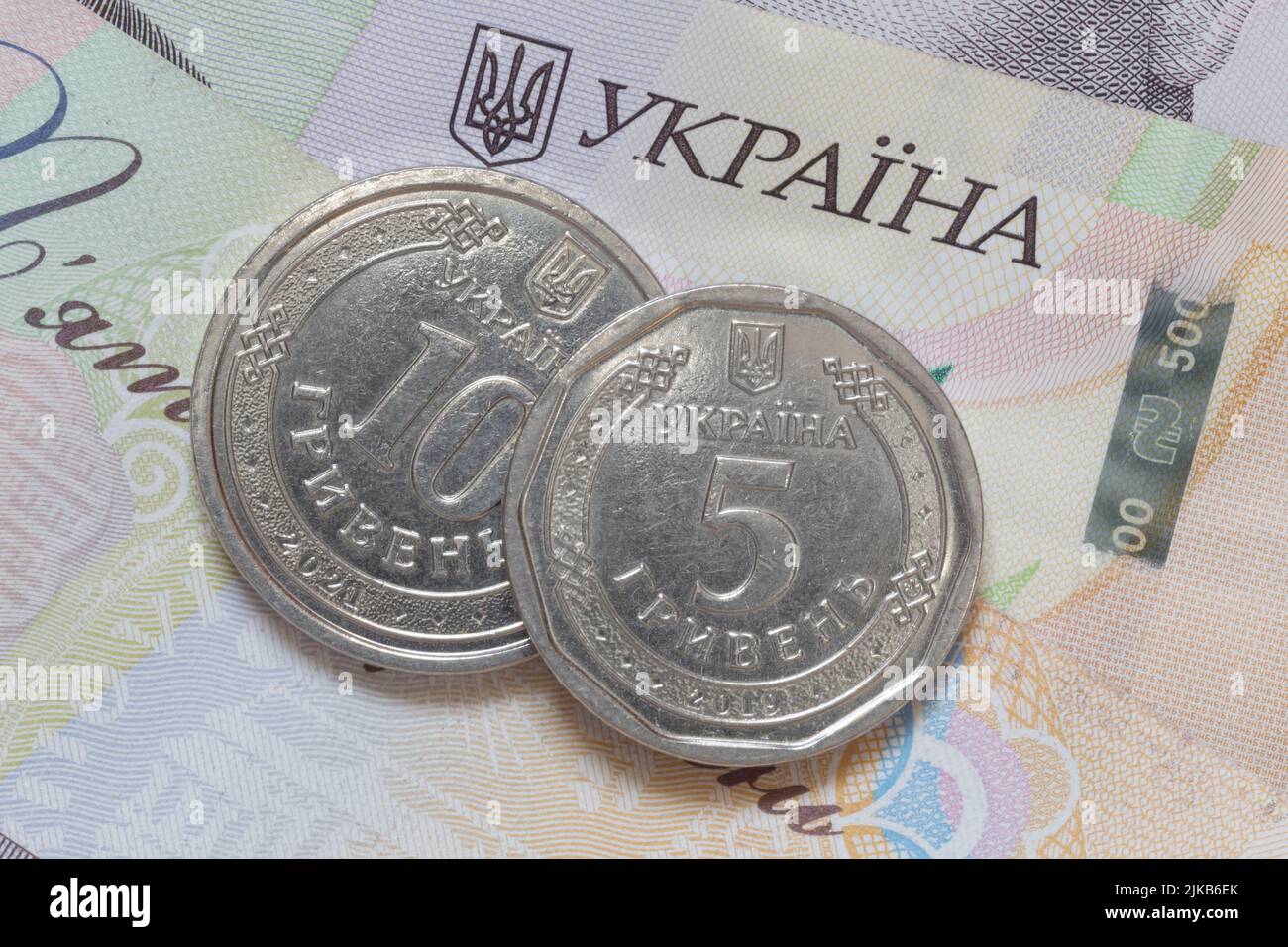 Primer plano de diez y cinco monedas ucranianas de hrivnya sobre quinientos billetes de hrivnya Foto de stock