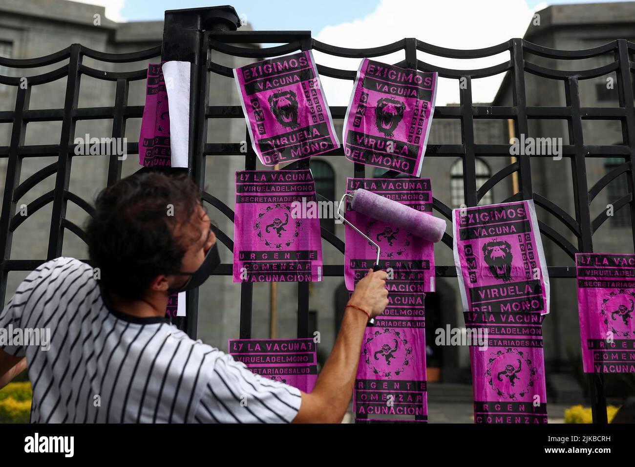 Un activista afiches en una valla durante una protesta para pedir una respuesta más fuerte del gobierno a la crisis de la viruela del simio, en las afueras del edificio de la Secretaría de Salud, en Ciudad de México, México, México, 26 de julio, 2022. REUTERS/Edgard Garrido Foto de stock