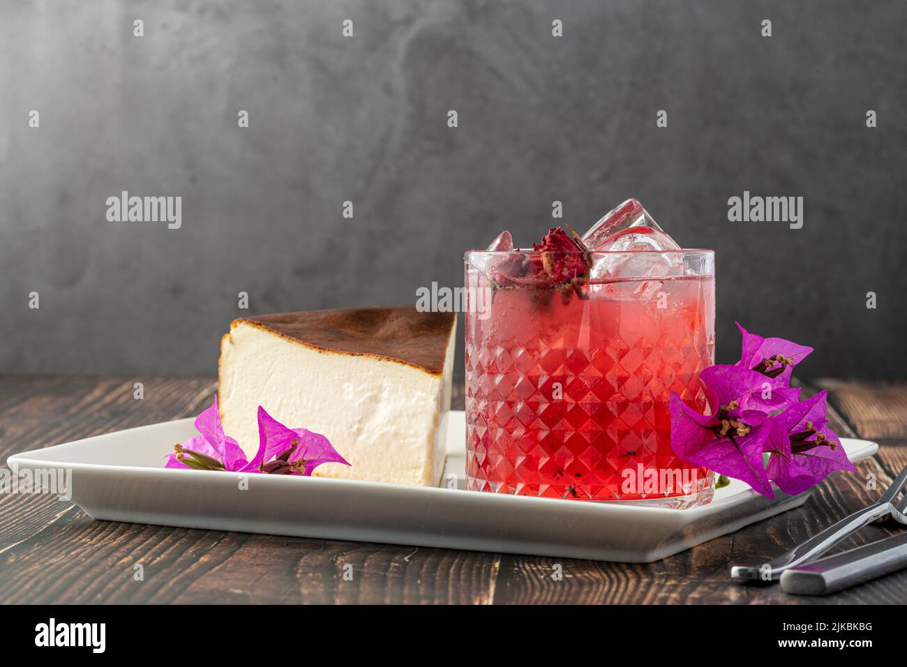 Té de fresa y tarta de queso de san sebastián sobre una mesa de madera Foto de stock