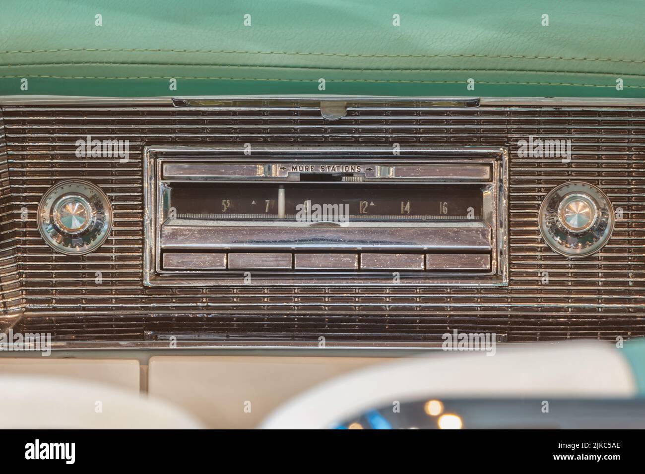 Antigua radio en el interior de un coche americano clásico verde con salpicadero cromado Foto de stock