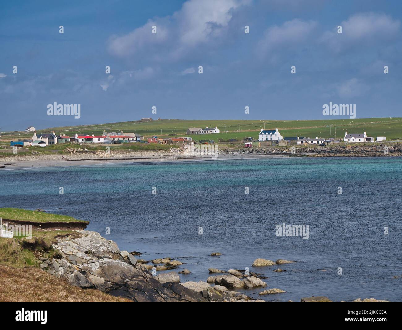 Al otro lado de las aguas de Sand Wick, la pequeña y remota comunidad de Sandwick en el sur de Mainland, Shetland, Reino Unido. Tomada en un día soleado con cielo azul. Foto de stock