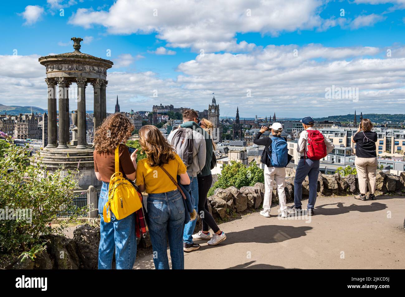 Turistas tomando fotos desde el emblemático mirador de Calton Hill sobre el horizonte de la ciudad, Edimburgo, Escocia, Reino Unido Foto de stock
