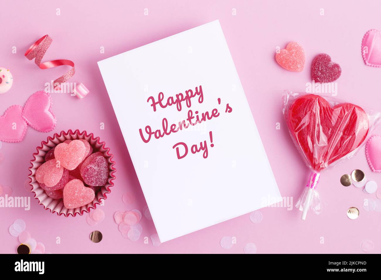 Feliz día de San Valentín Hermosa tarjeta de felicitación con corazones dulces y confeti. Rojo y los colores rosados, el plano ponen con las decoraciones del caramelo del amor del día de fiesta. Foto de stock