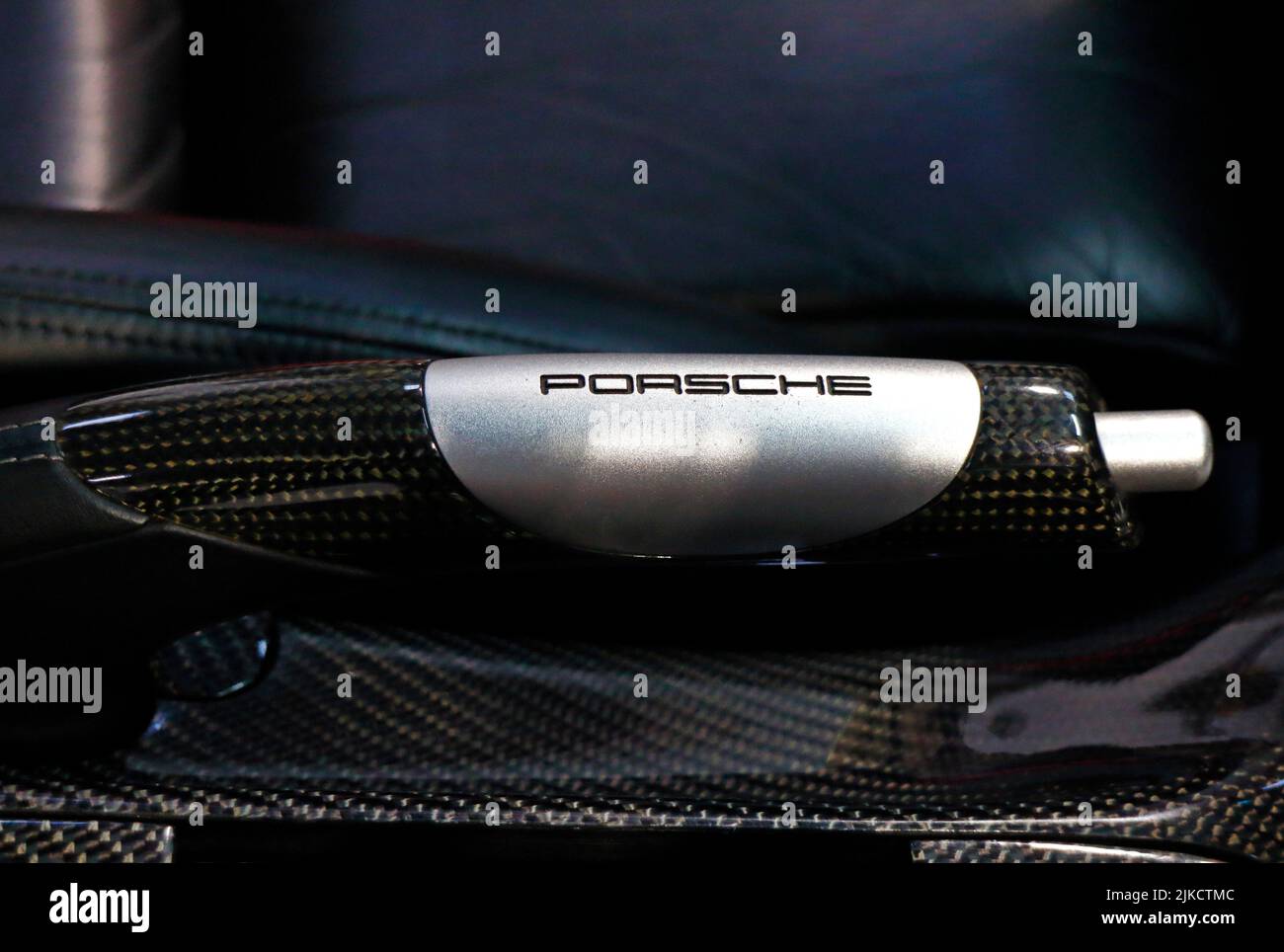 Detalle y primer plano del freno de mano por el asiento del conductor en un Porsche 911 Carrera GTS. Foto de stock