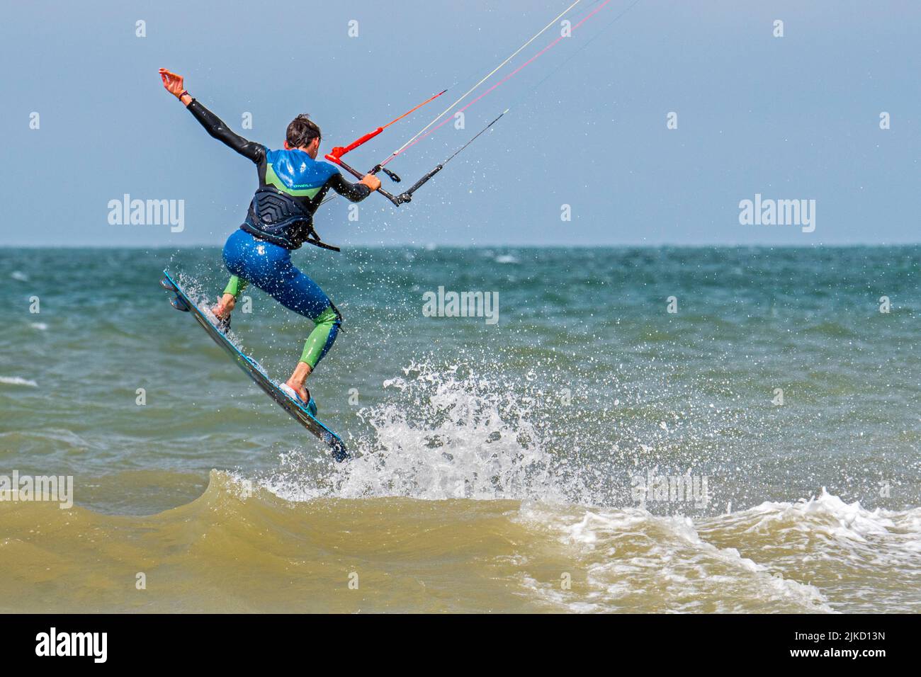 Kitesurf mostrando kiteboarder / kitesurfer en twintip board saltar en el Mar del Norte en un día de viento Foto de stock