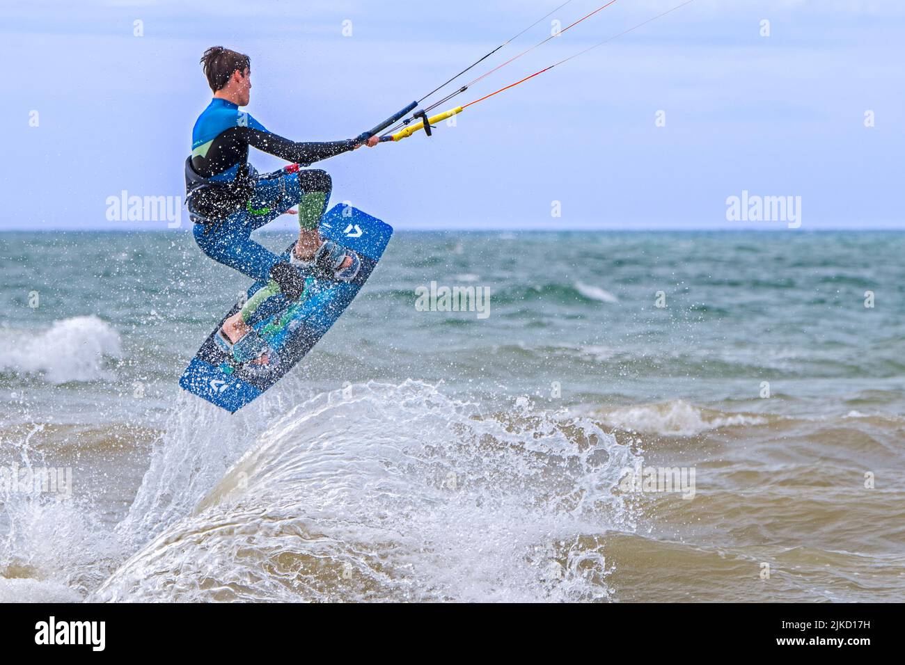 Kitesurf mostrando kiteboarder / kitesurfer en twintip board saltar en el Mar del Norte en un día de viento Foto de stock