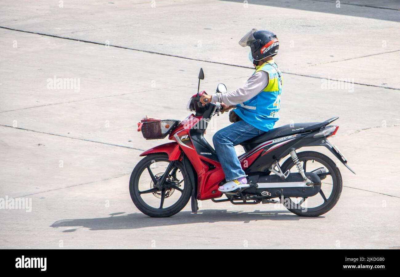 SAMUT PRAKAN, TAILANDIA, EL 30 2022 DE MAYO, el conductor de mototaxi en un viaje azul chaleco en la calle Foto de stock