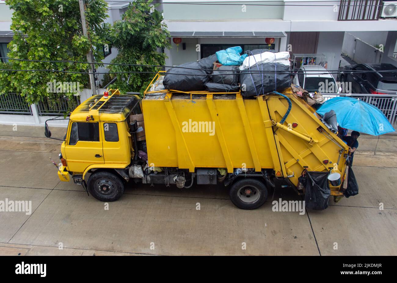 Un camión de basura está conduciendo en la calle Foto de stock