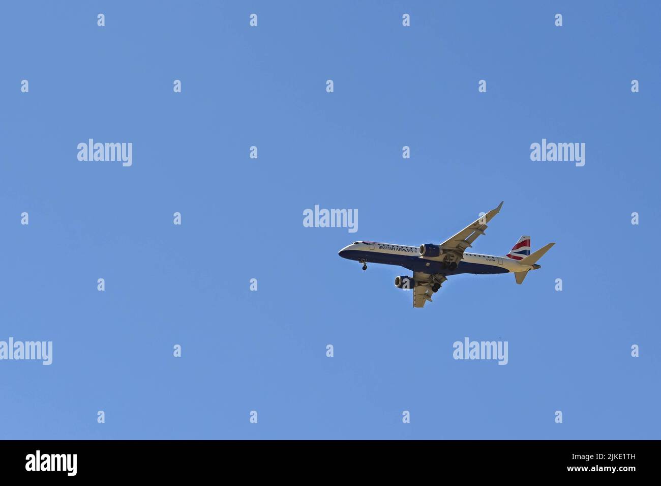 Londres, Reino Unido - Junio 2022: El avión Embraer de British Airways con ruedas hacia abajo se aproxima al aeropuerto de London City. Foto de stock