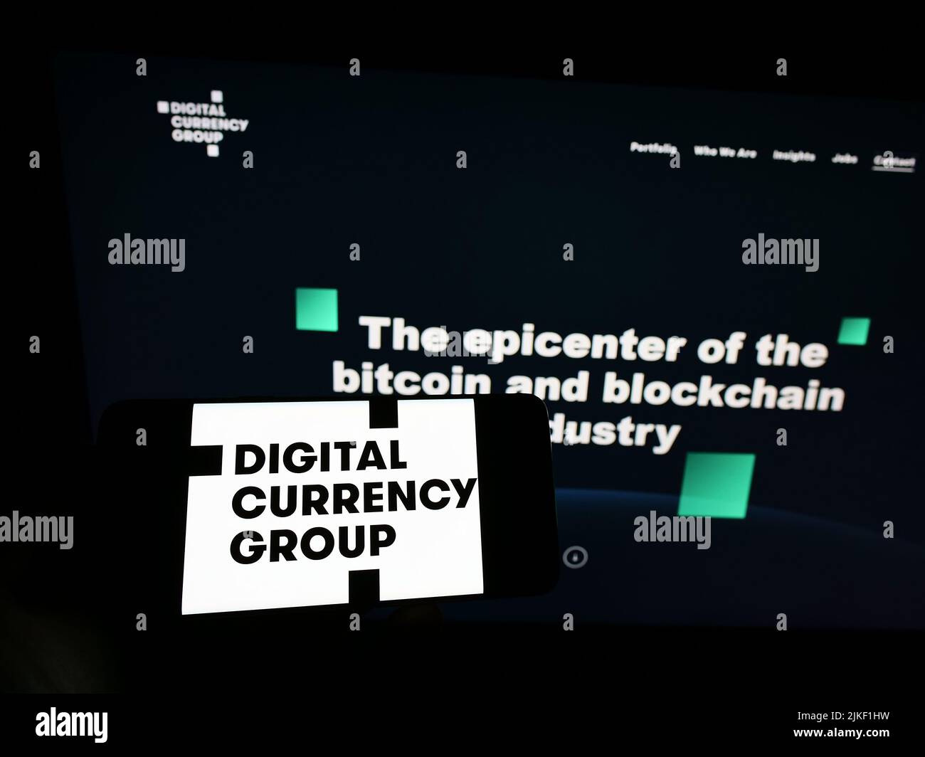 Persona que sostiene el teléfono móvil con el logotipo de la compañía